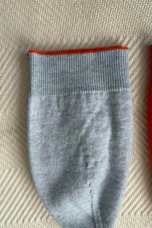 Grey 100% cashmere beanie with orange trim, expertly crafted in Ireland using premium, sustainably sourced textiles.