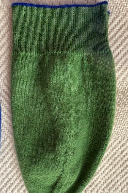 Green 100% cashmere beanie with blue trim, expertly crafted in Ireland using premium, sustainably sourced textiles.