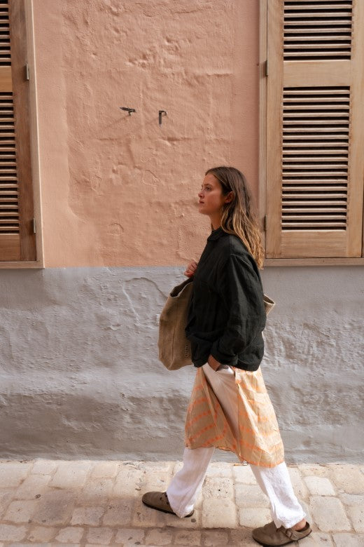 Dark green linen utility jacket crafted in Ireland, featuring boxy fit, signature buttons, and orange stitch detail.