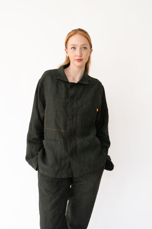 Dark green Irish linen chore jacket with orange stitching, button front, and boxy fit, handcrafted by Irish makers.