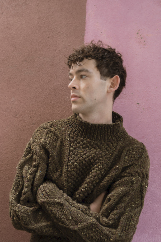 Hand-knit olive merino wool Aran jumper with blackberry stitch, crafted by Irish makers in a relaxed boxy fit.