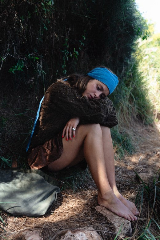 Woman wearing a dark brown, hand-knit merino wool Aran jumper, crafted by Irish artisans with traditional textures.