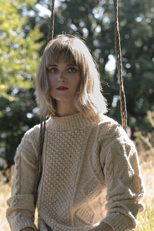 Cream merino wool Aran jumper with blackberry stitch, hand-knit by Irish artisans in a relaxed, boxy fit.