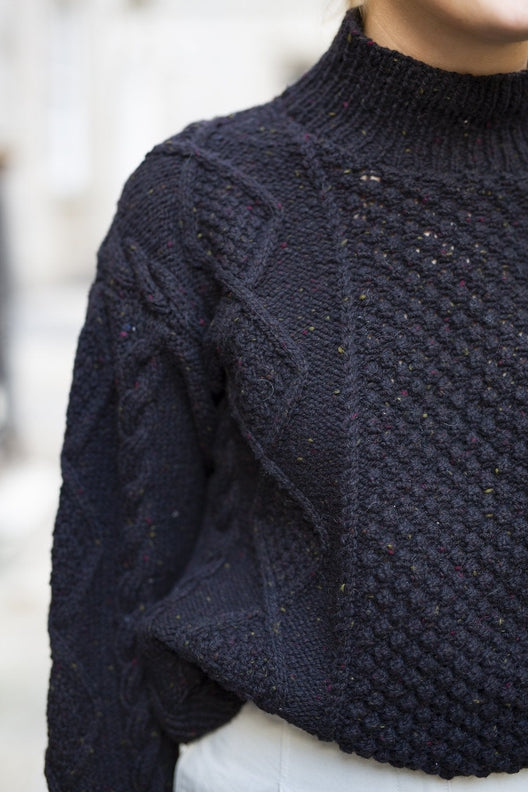 Handknit navy merino wool Aran jumper with blackberry stitch, crafted by Irish artisans for a relaxed, high-quality fit.