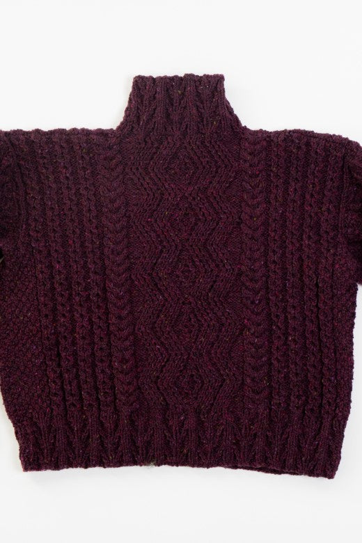 Deep purple handknit merino wool Aran jumper featuring traditional blackberry stitch, crafted by Irish artisans.