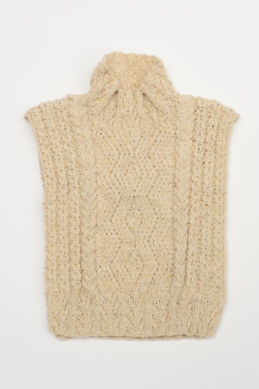 Cream-colored handknit Aran cable body bib, artisan-made in Donegal with high-quality wool featuring intricate textures.