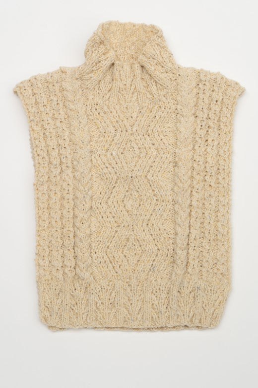 Cream-colored handknit Aran cable bib, crafted in Donegal with high-quality wool featuring intricate diamond patterns.