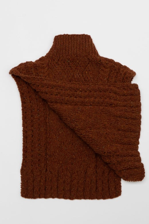 Hand-knit rust brown Aran cable bib by Irish maker Muriel, featuring high-quality wool and intricate textured detailing.