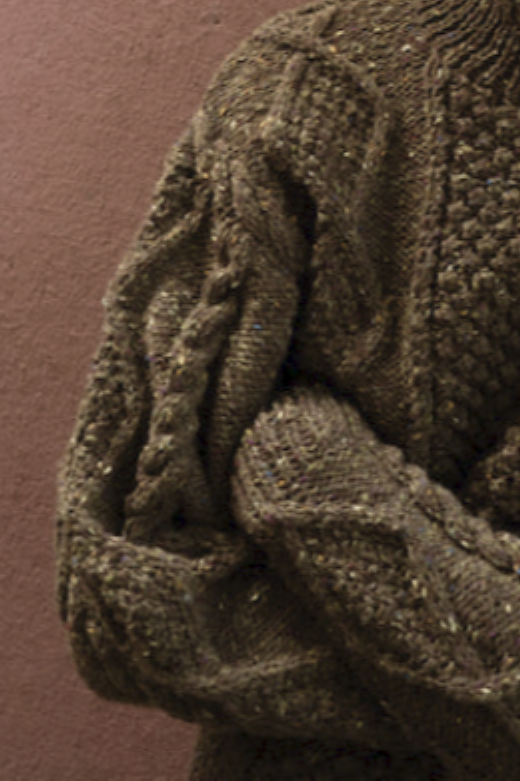 Hand-knit olive merino wool Aran jumper featuring traditional blackberry stitch, crafted by Irish artisans for a relaxed fit. Unisex