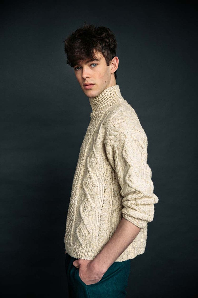 Cream merino wool handknit Aran jumper with blackberry stitch, crafted by Irish artisans for a relaxed, high-quality fit.
