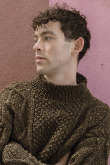 Hand-knit olive merino wool Aran jumper featuring traditional blackberry stitch, crafted by Irish artisans for a relaxed fit.