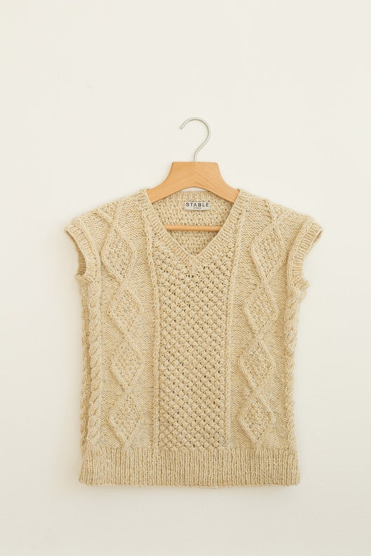 Hand-knitted Irish Aran sleeveless vest in flecked cream merino wool with traditional cable stitches and a V-neck.