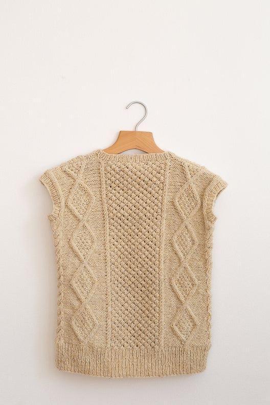 Hand-knitted Irish Aran sleeveless vest in flecked cream merino wool featuring traditional cable-knit patterns.