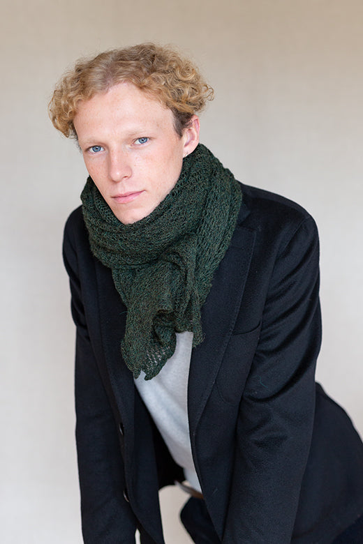 Peat green, artisan-knit alpaca lace scarf handcrafted in Ireland, draped elegantly around the neck.