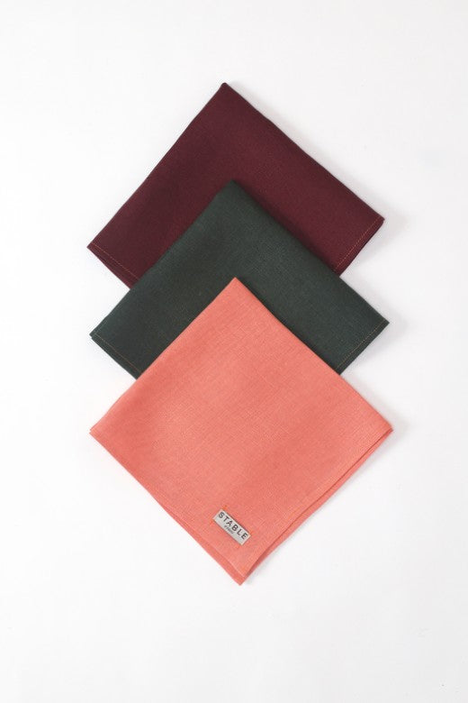Set of three heavy-weight Irish linen napkins in burgundy, forest green, and coral, handmade in Ireland by STABLE.