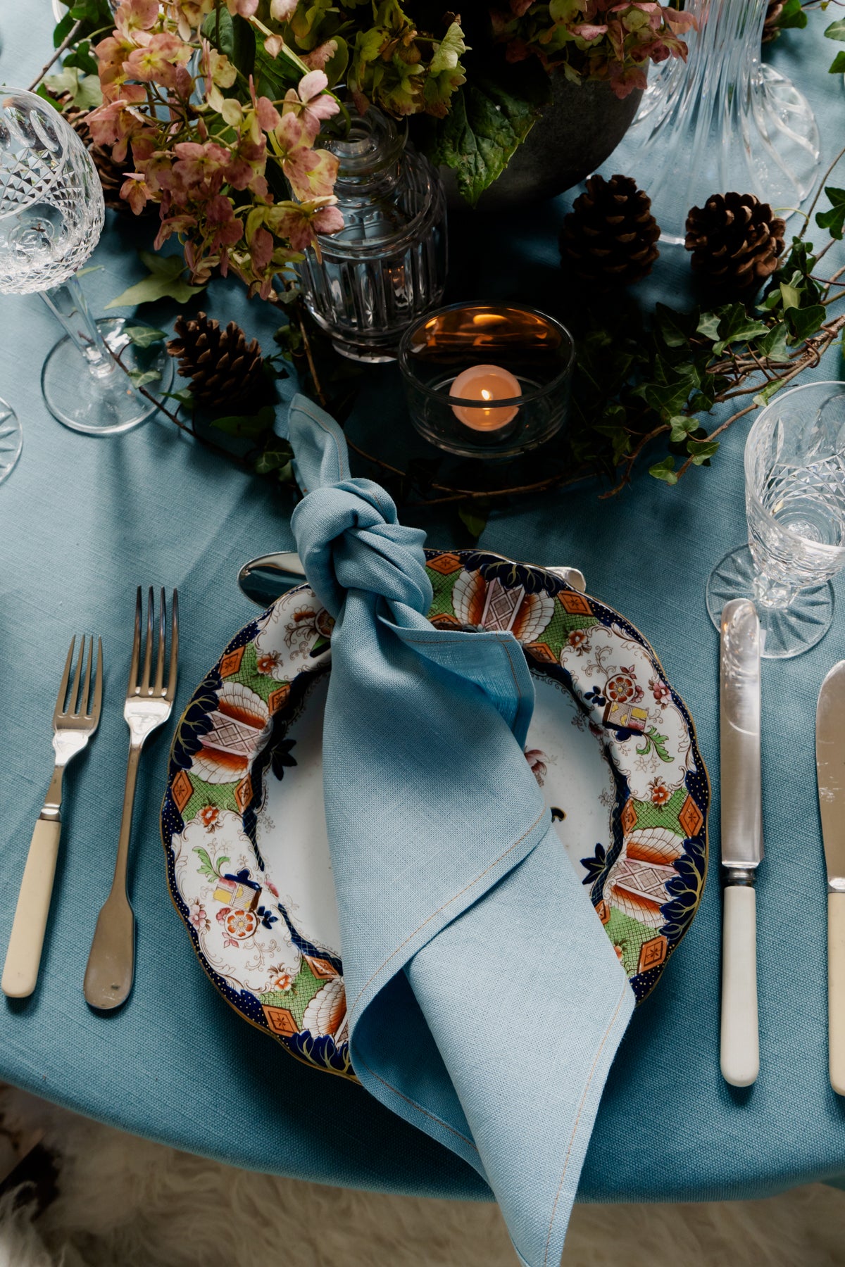 Handmade heavy-weight Irish linen napkin in soft blue, styled on a decorative plate by Irish craftspeople.
