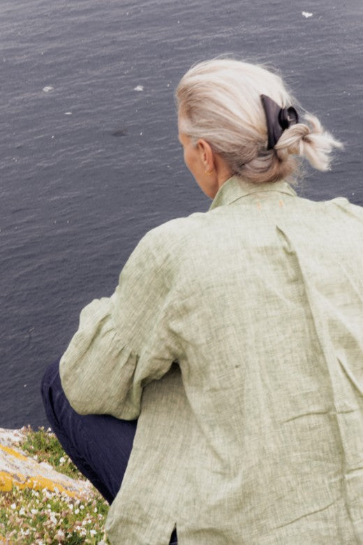 Sophie Darlington wearing a loose-fit grey Irish linen work shirt, crafted by Irish makers for functional outdoor wear.