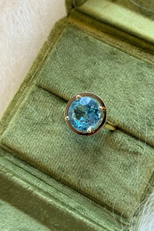 The April Sky Blue Topaz Gold Halo Ring