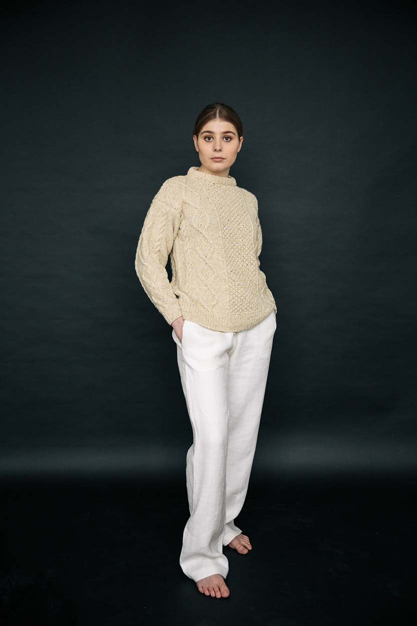 Cream merino wool handknit Aran jumper with blackberry stitch detail, crafted by Irish artisans for a relaxed fit.