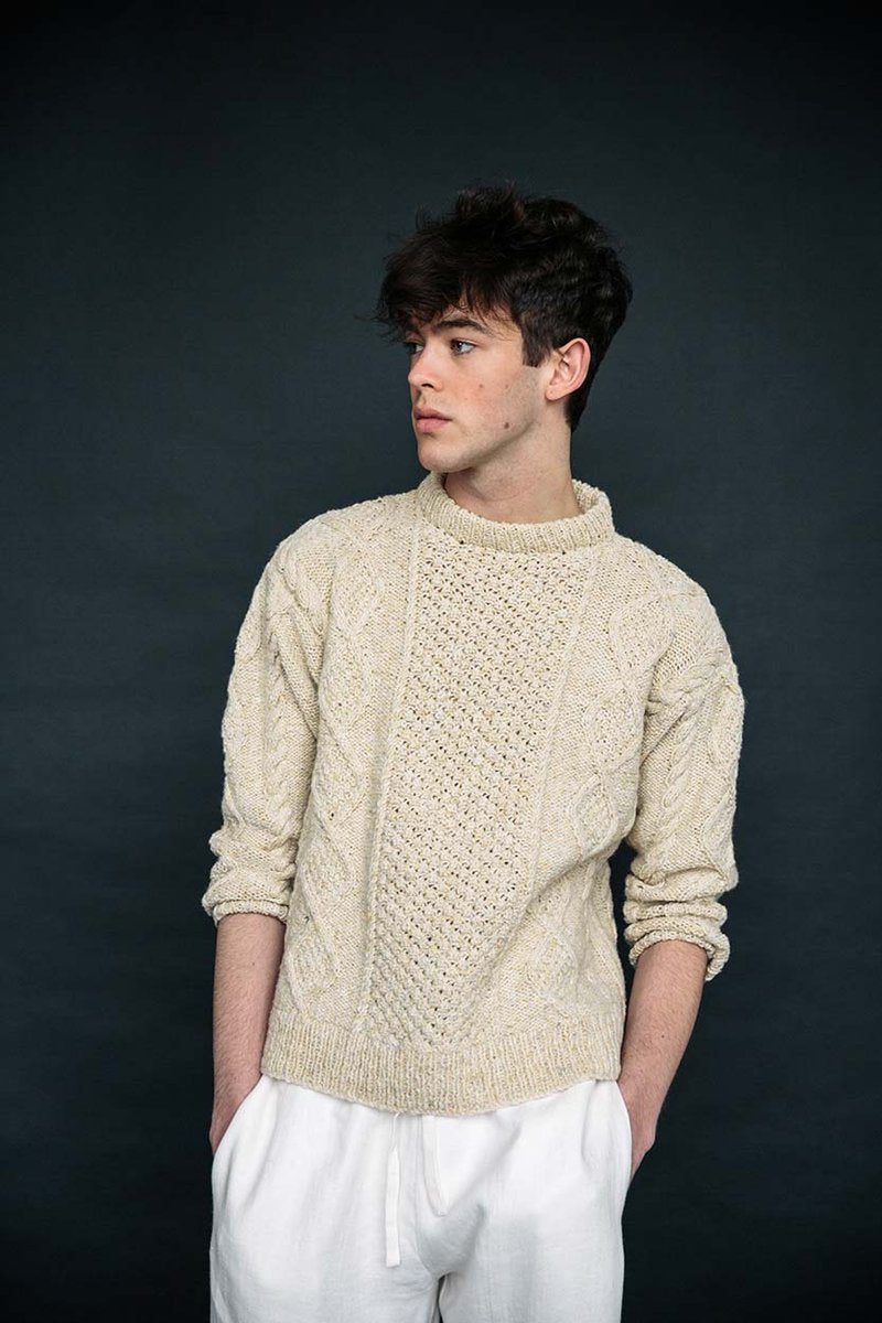 Cream merino wool Aran jumper handknit by Irish artisans, featuring a relaxed fit and traditional blackberry stitch detail.