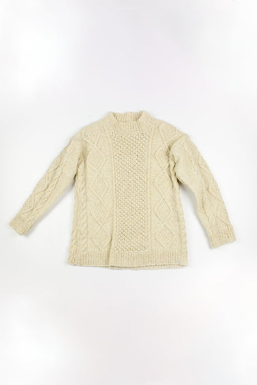 Cream merino wool Aran jumper hand-knit in Ireland, featuring traditional blackberry and cable stitch patterns.