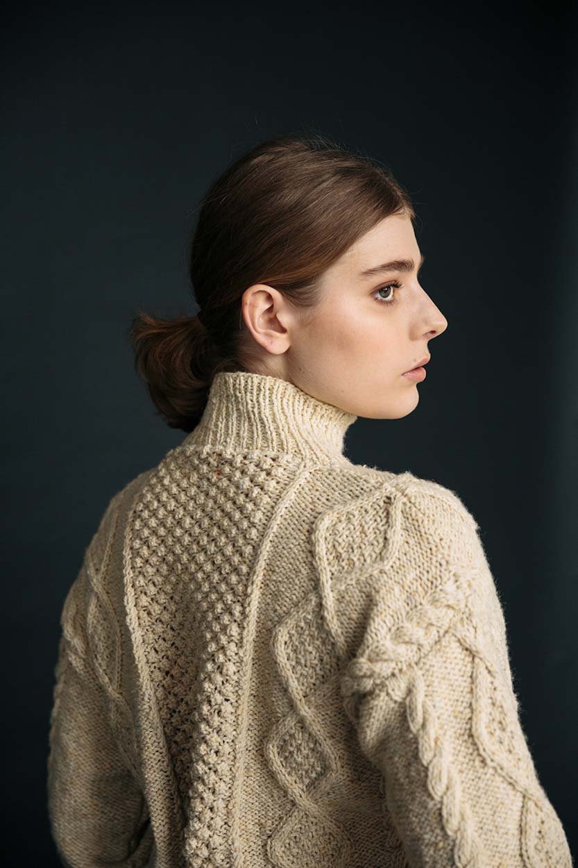 Cream merino wool Aran jumper with blackberry stitch, hand-knit by Irish artisans for a relaxed, high-quality fit.