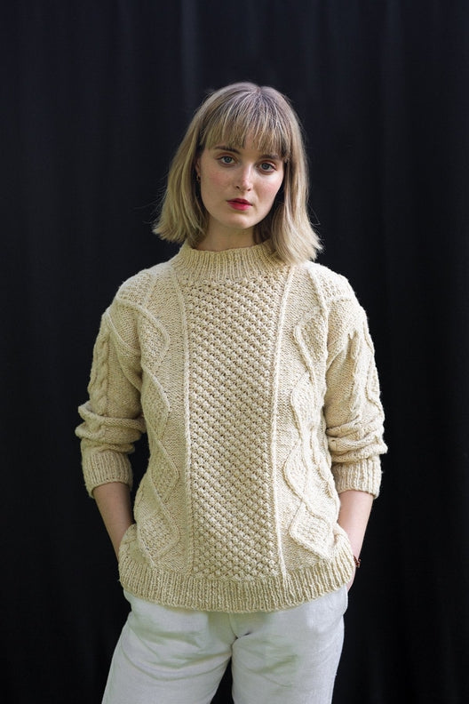 Cream merino wool Aran jumper with blackberry stitch, hand-knit by Irish artisans for a relaxed, high-quality fit.