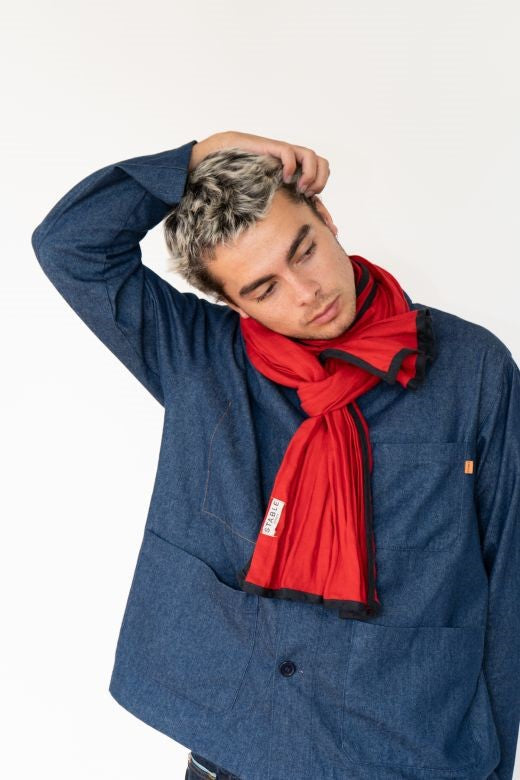 Man wearing a red Irish linen scarf with navy trim, handcrafted by Irish makers from high-quality, sustainable natural fibers.
