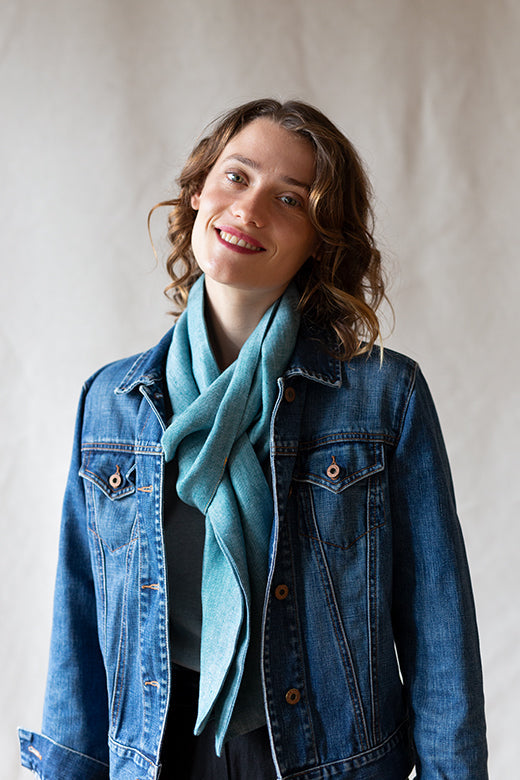 Woman wearing a Connemara blue herringbone Irish linen scarf, handcrafted from high-quality sustainable linen.