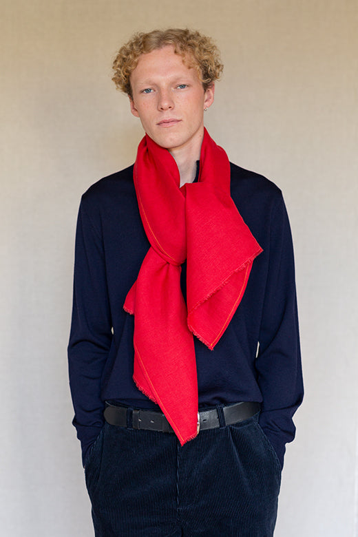 A vibrant red Irish linen scarf with frayed edges, handcrafted by Irish makers from high-quality, sustainable flax.